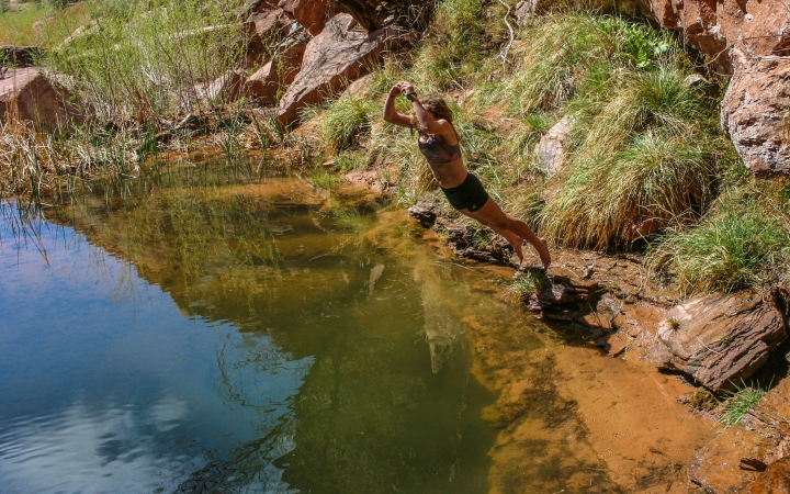 A person is mid-jump into a body of water.